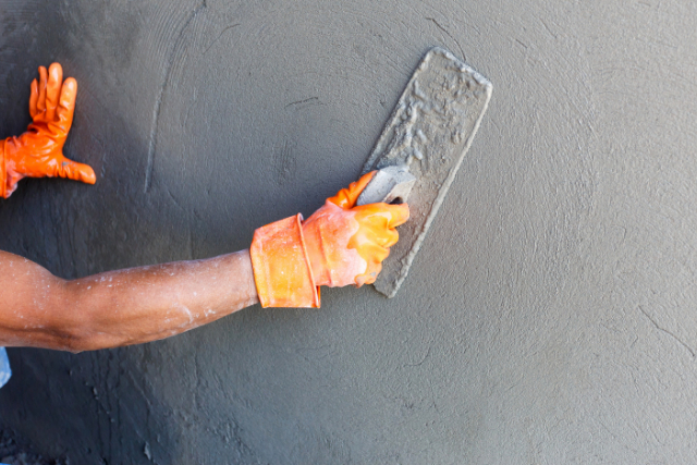 Concrete resurfacing wall by a worker with tool