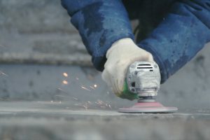 Resurfacing concrete wall by a worker with a power tool